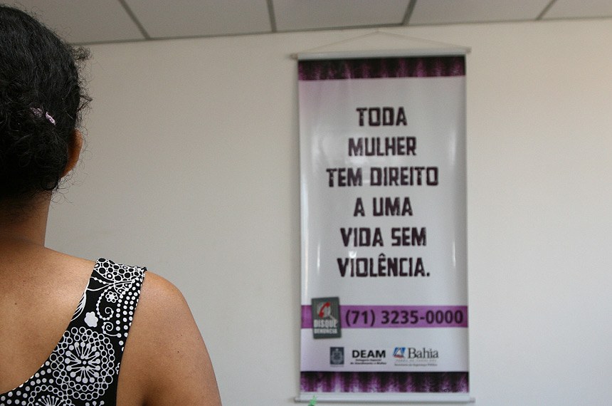 notícia: Vira lei obrigação de notificar casos de violência contra a mulher em 24 horas. Cores: branco, roxo e preto. 