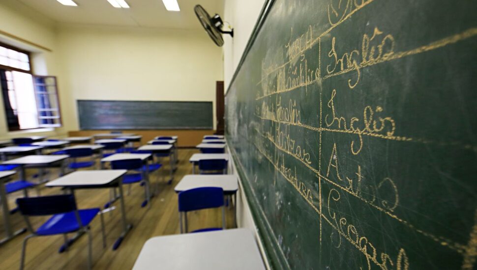 #pratodosverem: notícia: Professores estaduais do Paraná aprovam greve pelo não retorno às aulas em 2020. Na foto, uma sala de aula vazia. Cores na imagem: verde, branco, azul, laranja e verde. 